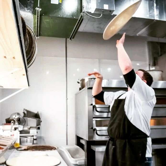 Pizzaïolo de FBI Pizza qui lance la pâte dans la cuisine d'Etobicoke